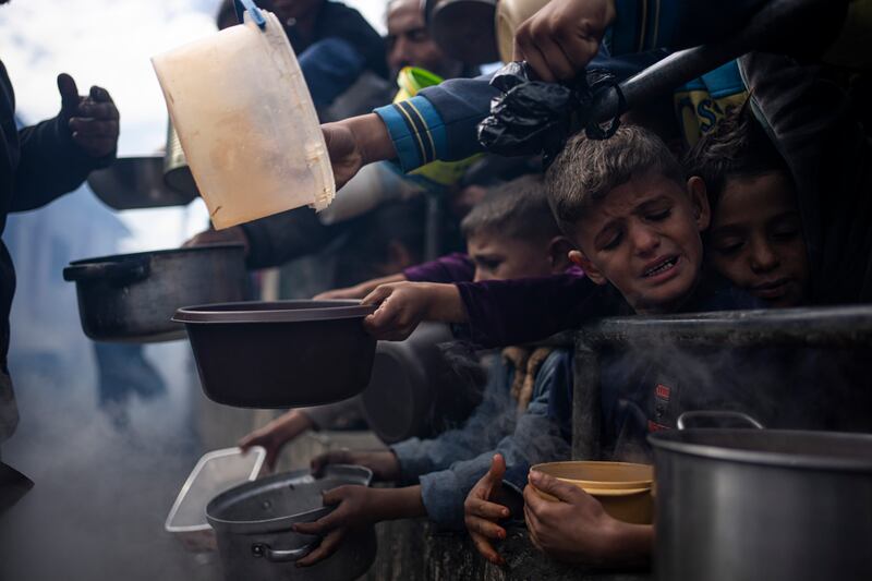 Palestinians line up for food in Rafah (Fatima Shbair/AP)