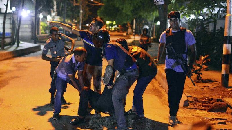 People help an unidentified injured person after the attack. Picture by Associated Press