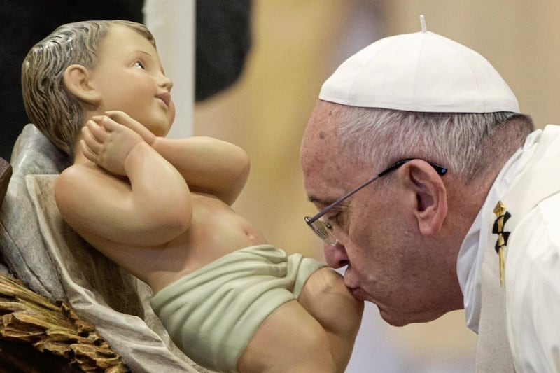 Pope Francis kisses a statue of the baby Jesus in St Peter&#39;s Basilica at the Vatican. Christmas recalls how the Lord became part of his creation, allowing himself to become a baby as he set out on his salvation mission. Picture by AP Photo/Andrew Medichini 