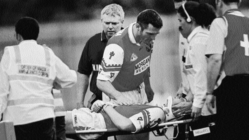 CONCERN... Armagh team captain Jarlath Burns and joint manager Brian McAlinden look on anxiously as the injured Alan O'Neill is stretchered off by Order of Malta Ambulance Corps personnel&nbsp;