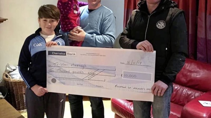 Former Tyrone player Chris Lawn presents a cheque for &pound;10,000 to St Malachy&rsquo;s, Moortown big draw winner Tristan Meenagh. Also pictured are Tristian&rsquo;s father Colm and sister Elyse Pia. The list of winners was as follows: Tristan Meenagh (Killyclogher) &pound;10,000, Gemma O&rsquo;Neill (Ballymaguigan) &pound;5,000, Ryan Murray (Lissan) &pound;2,000, Chrissie Devlin (Moortown) &pound;1,000, Ann Quinn (Kinrush Road, Moortown) &pound;500, Peter McDermott (Enniskillen) &pound;500, Calum O&rsquo;Boyle (Portglenone) &pound;250, Henry Bradley (Cookstown) &pound;250, Joe McGuckin (Bush Rod, Dungannon) &pound;250 and Denise O&rsquo;Hagan (Desertmartin) &pound;250 