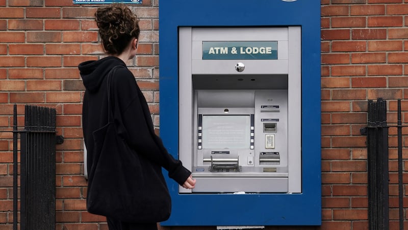 A person passes an out of service ATM at a Bank of Ireland branch (PA)