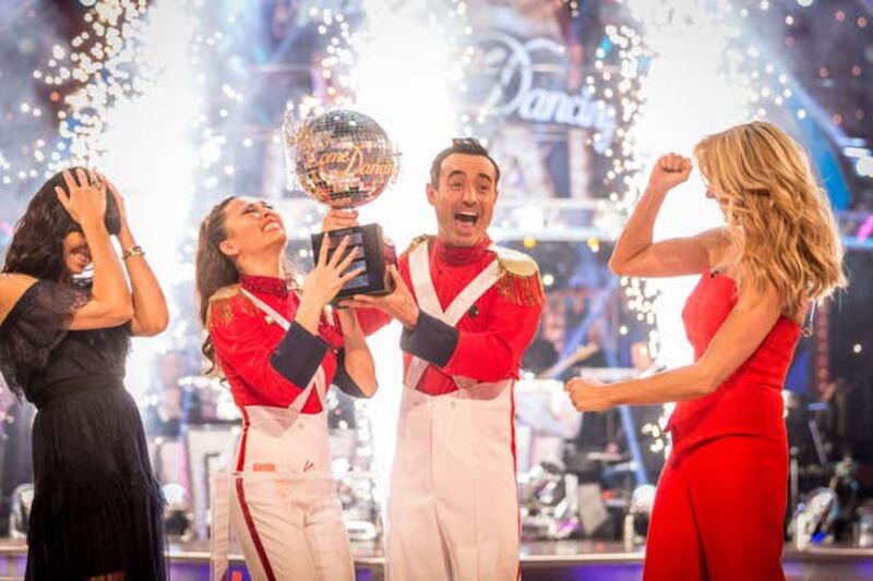 Claudia Winkleman (left) and Tess Daly (right) present Katya Jones and Joe McFadden with the glitterball trophy after they won the final of the BBC 1 show Strictly Come Dancing (BBC/PA)