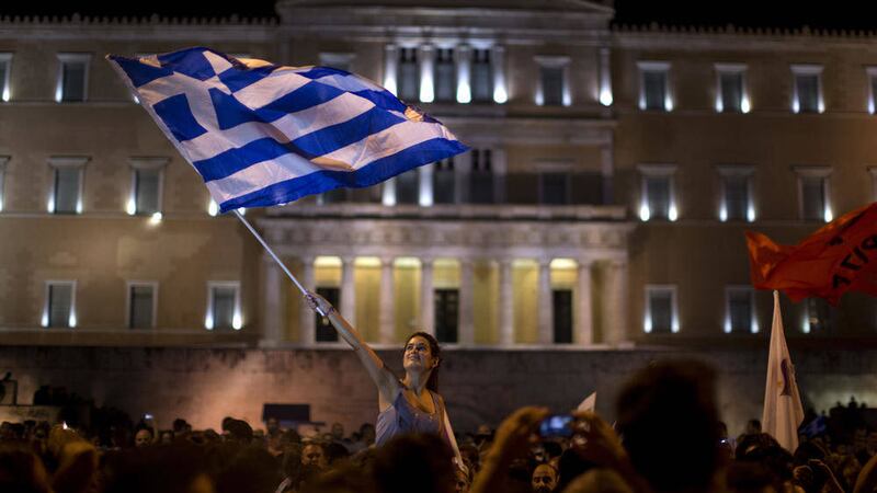 A supporter of the No vote waves a Greek flag in front of the parliament after the results of the referendum at Syntagma square in Athens 