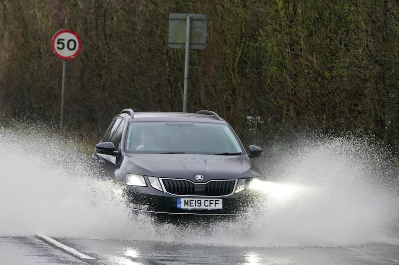 Traffic goes through a flooded road near Folkestone, Kent