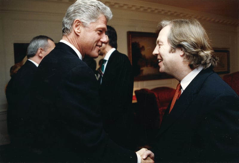 a photo of US President Bill Clinton shaking hands with Eamonn Mallie