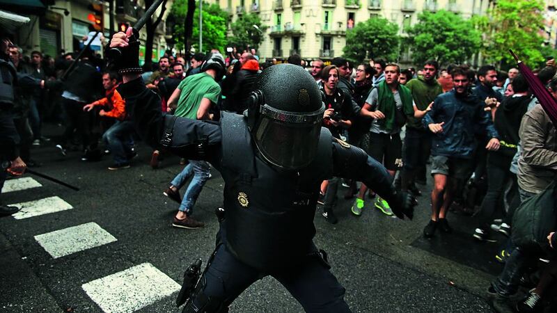 Spanish riot police swings a club against would-be voters near a school assigned to be a polling station by the Catalan government in Barcelona, Spain, Sunday, Oct. 1, 2017. Spanish riot police have forcefully removed a few hundred would-be voters from several polling stations in Barcelona. picture by Manu Fernandez, AP Photo.