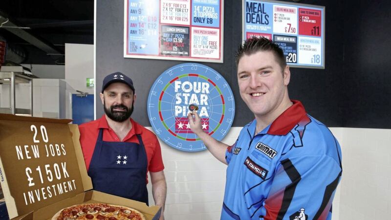 Scott Higginson, managing director of the new Dundonald Four Star Pizza store, is joined by world number five-rated darts star Daryl Gurney to celebrate the opening of the pizza chain&rsquo;s 50th store 