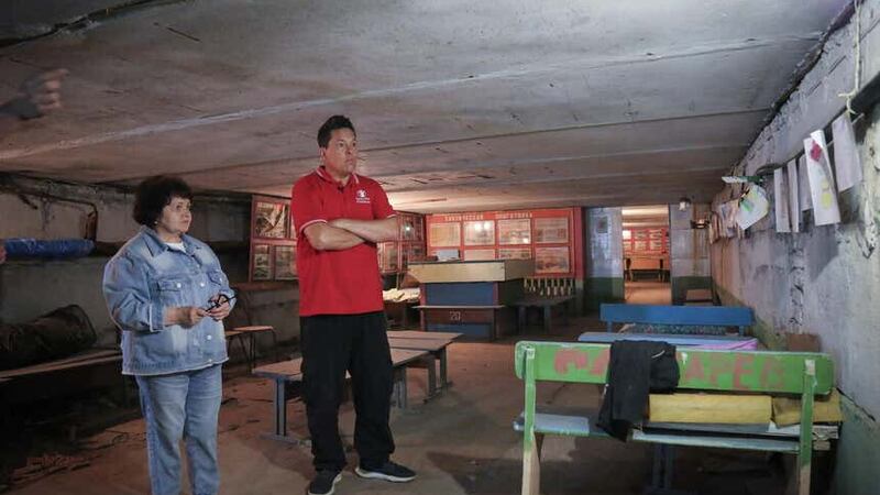 Vice principal Halyna* 64 with Dom Joly in the bomb shelter of her destroyed school (Simon Edmunds/Save the Children/PA)