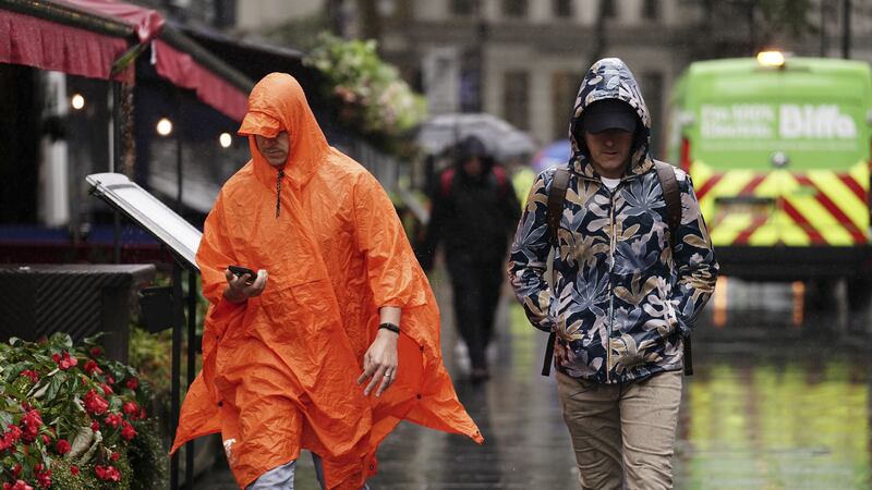 People caught during a heavy downpour of rain in Leicester Square, London (Jordan Pettitt/PA)