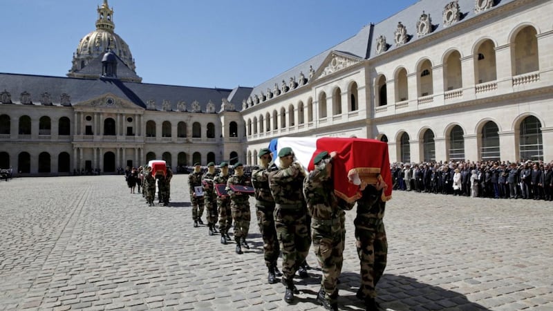 Special forces soldiers carry the flag-drapped coffins of late special forces soldiers Cedric de Pierrepont and Alain Bertoncello, who were killed in a night-time rescue of four foreign hostages including two French citizens in Burkina Faso last week, during a national tribute at the Invalides, in Paris, on Tuesday. Picture by Philippe Wojazer, Pool via Associated Press. 