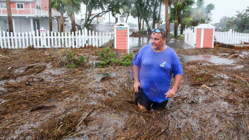 Daniel Dickert wades through water in front of his home in Florida (Douglas R. Clifford/Tampa Bay Times/AP)