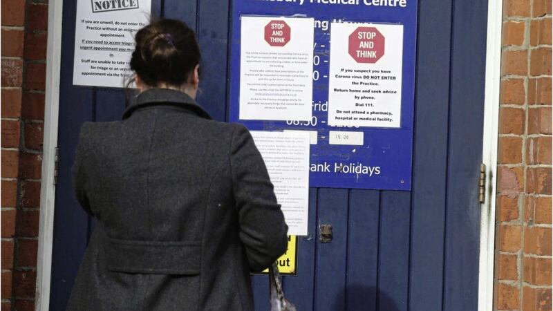 A woman reads a &#39;Stop and Think&#39; sign on the door of Salisbury Medical Centre in north Belfast yesterday. Picture by Hugh Russell 