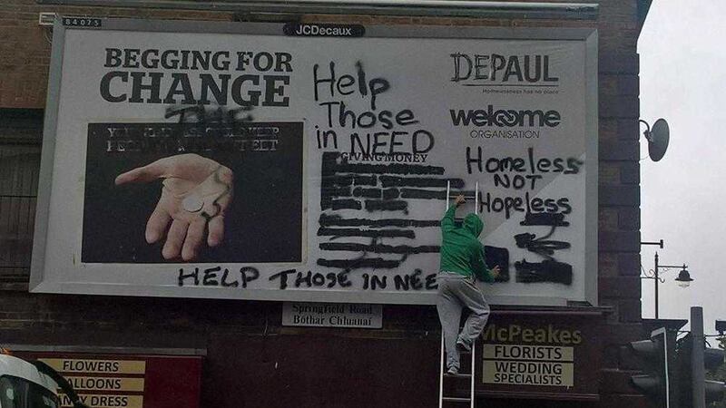 A man on a ladder defaced a billboard calling on people not to give cash to people who ask for cash on the streets 