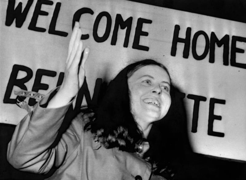 Bernadette Devlin in front of a 'Welcome home Bernadette' banner
