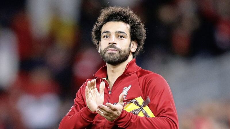 Liverpool&#39;s Mohamed Salah applauds the fans holding a present from a member of the crowd after the Champions League victory over Red Star Belgrade 