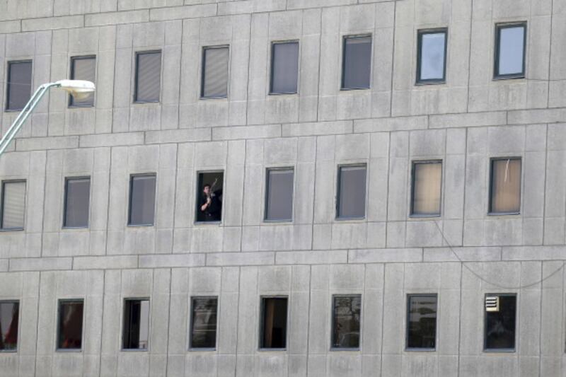 An armed man can be seen in the window of the parliament building (Omid Vahabzadeh/AP)