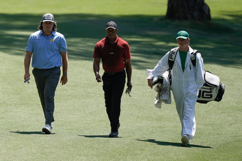 Amateur Neal Shipley (left) and Woods (centre) walk to the green on the 16th hole during the final round at the Masters (Charlie Riedel/AP)