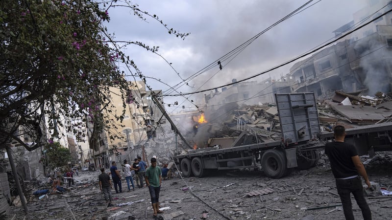 Palestinians walk amid the rubble following Israeli airstrikes that razed swaths of a neighborhood in Gaza City. Picture by AP Photo/Fatima Shbair