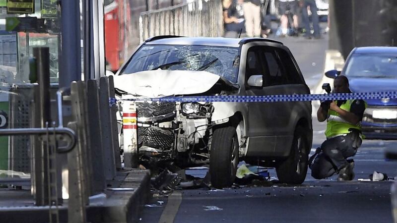 Police arrested two men after a car ploughed through a crowd on Flinders Street in Melbourne. Picture from Associated Press 