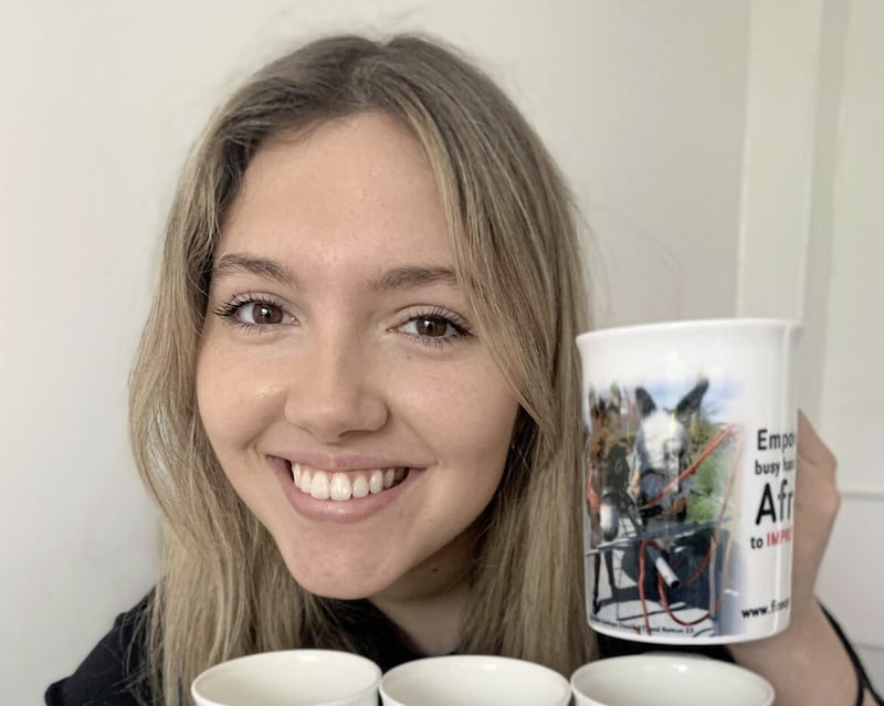 Patrick Finnegan's daughter Chloe showing off the fundraising mugs