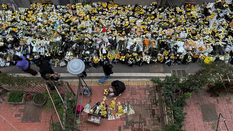 Residents walk by flowers laid outside a residential building where the late Chinese Premier Li Keqiang spent his childhood (Chinatopix via AP/PA)