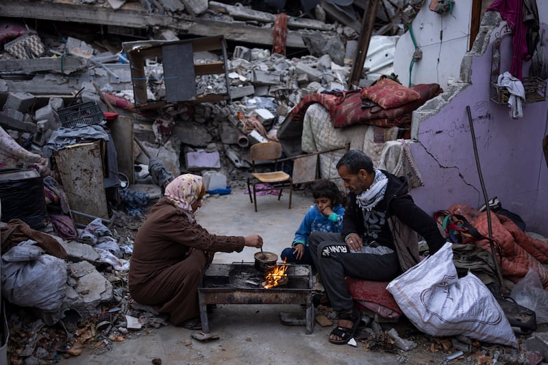 Members of the Al-Rabaya family break their fast during the Muslim holy month of Ramadan outside their destroyed home by the Israeli airstrikes in Rafah (AP)