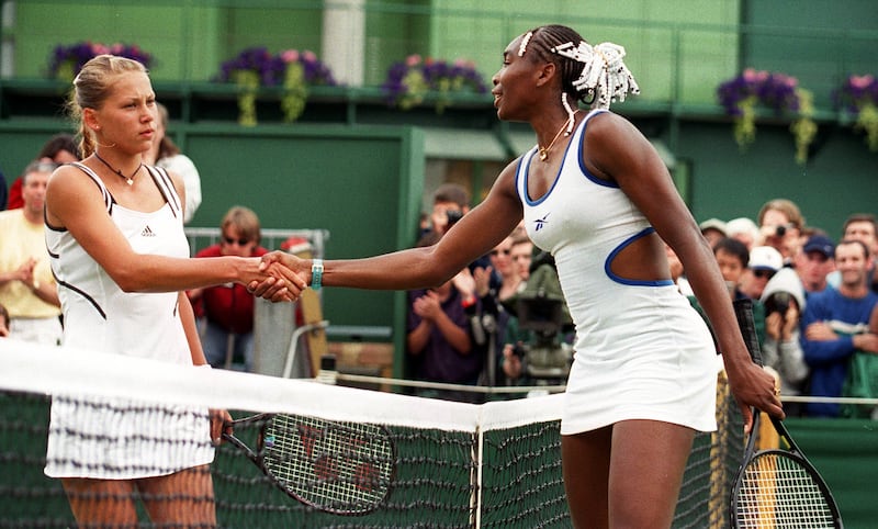 Anna Kournikova (left) shakes hands with Venus Williams of USA, after losing her match to the American at the 1999 Wimbledon tennis Championships