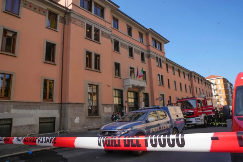 Police and firefighters at the scene of the nursing home blaze in Milan 