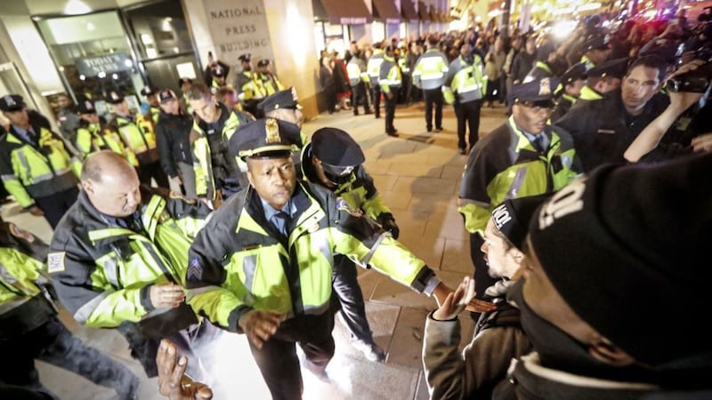 Police push protesters off the sidewalk in front of the National Press Building in Washington. Picture by John Minchillo, Associated Press 