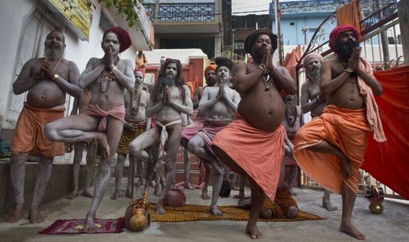 Hindu holy men perform Yoga as others follow to mark the International Yoga Day at Kamakhya temple in Gauhati, India (Anupam Nath/AP)