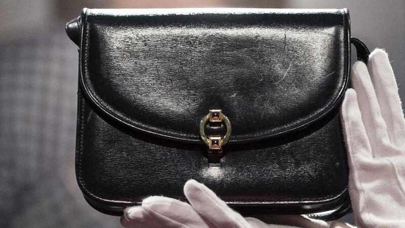A Christie&#39;s staff member holds a leather handbag owned by Margaret Thatcher. Picture by Lauren Hurley/PA Wire. 