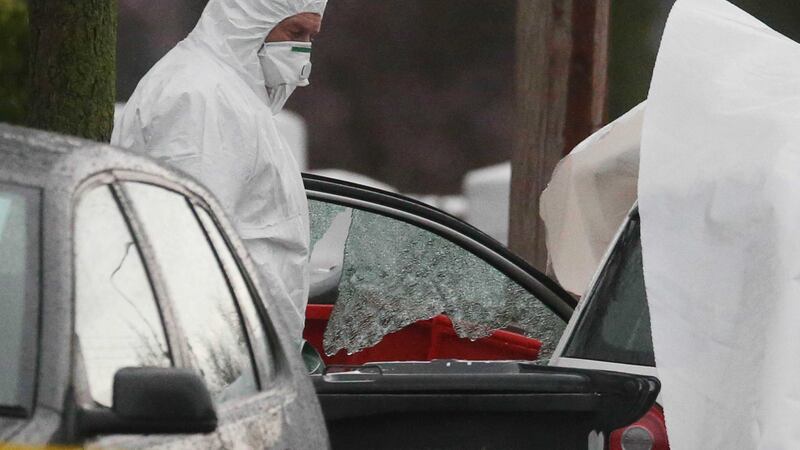 A forensics officer beside a broken car window at the scene of the shooting on McKee Road in Finglas, Dublin