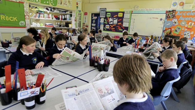 Pupils at St John the Baptist PS with The Irish News School Edition. Picture by Hugh Russell 