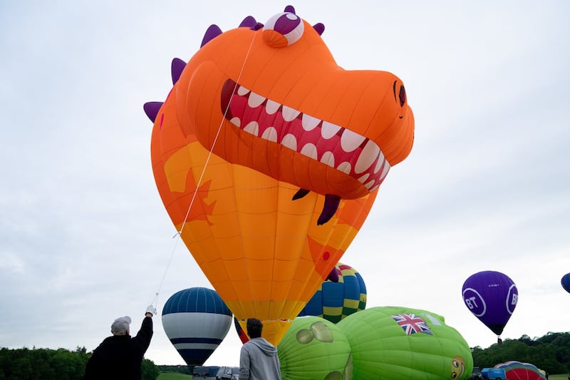 A scaly dragon-like creature bared its teeth as the balloon inflated (Jacob King/PA)