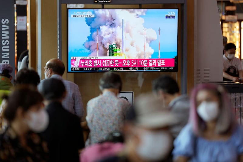 A TV screen shows a news programme about South Korea’s rocket launch at a train station in Seoul
