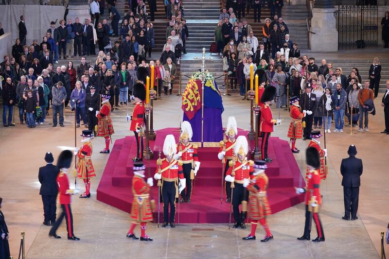 The guard is changed as members of the public file past the coffin of the Queen lying in state in Westminster Hall 