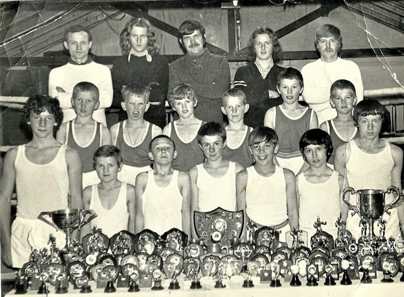 The brilliant young Holy Trinity boxing squad of the mid-1970s display their huge haul of trophies at the clubrooms in Turf Lodge in west Belfast 