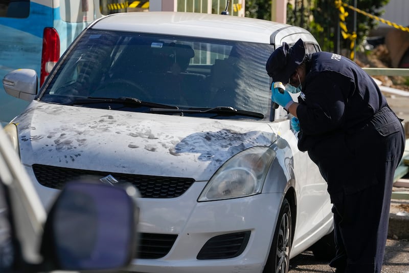A police forensic officer inspects a car at the Christ the Good Shepherd Church in Wakely in western Sydney (Mark Baker/AP)