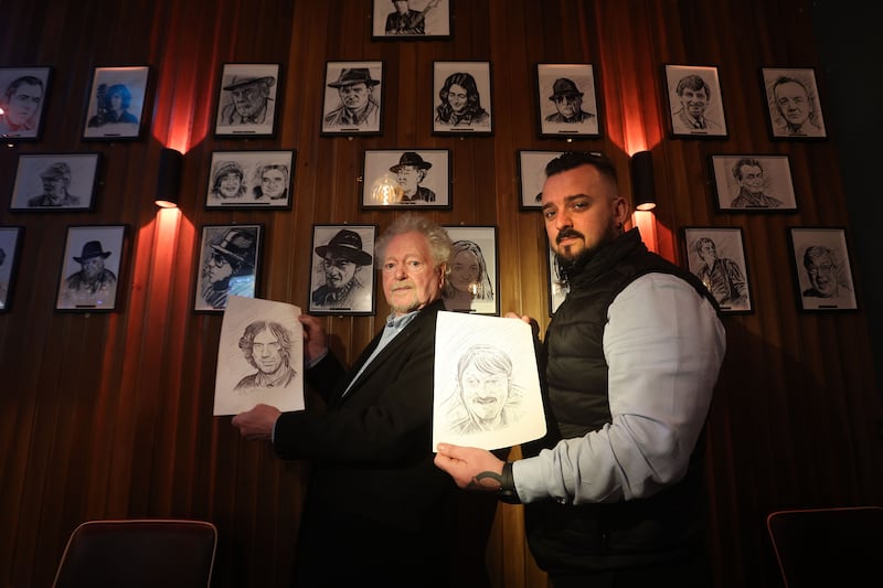 Artist Alan Quigley with his black and white sketches of local famous characters on display at the Monico bar, Lombard Street Belfast pictured with manager Declan Martin. Picture Mal McCann.