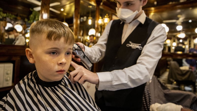 Stephen Hill cutting the hair of six-year-old Ruairi Gargan at Cambridge Barbershop on Belfast's Lisburn Road, which opened at 00:01. Picture by Liam McBurney/PA Wire&nbsp;
