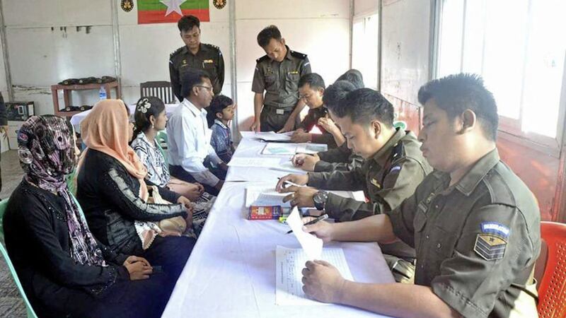Myanmar immigration officials examine documents of a Rohingya family of five at a receiving centre in Taung Pyo, Letwe, northern Rakhine state Picture by Myanmar Government Information Committee via AP 