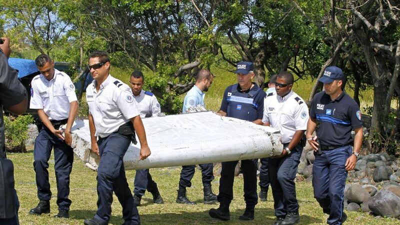 French police officers carry a piece of debris from a plane in Saint-Andre, Reunion Island. 