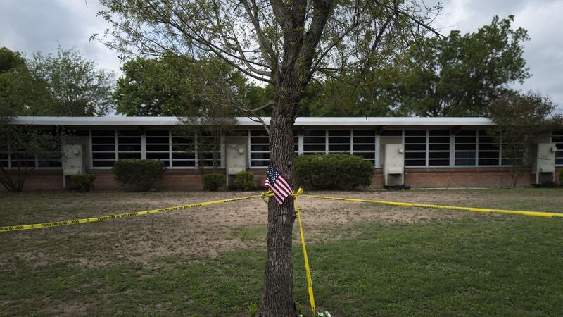 A school building stands behind a tree with an American flag and crime scene tape at Robb Elementary School in Uvalde, Texas Monday, May 30, 2022 (AP Photo/Jae C Hong)&nbsp;