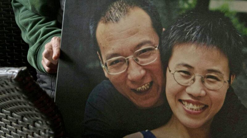 Liu Xia, wife of 2010 Nobel Peace Prize winner Liu Xiaobo, poses with a photo of her and her husband during an interview at her home in Beijing Picture: Ng Han Guan/AP 