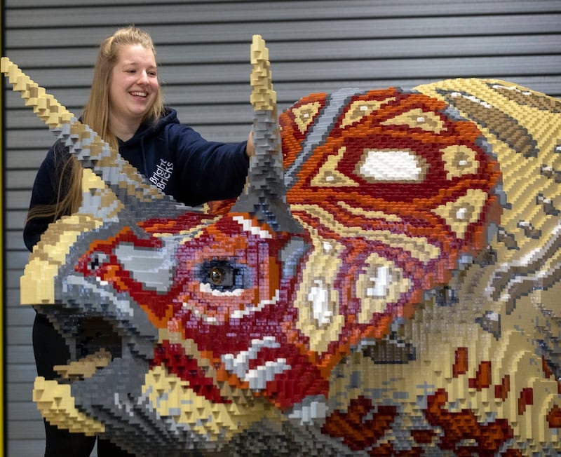 Bright Bricks member of staff Zoe Aris works on one of the brick dinosaurs made out of Lego