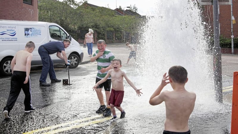 Children grab the chance to play at a burst water pipe in 2016 before an official from Northern Ireland Water arrives to repair it. Picture by Cliff Donaldson 