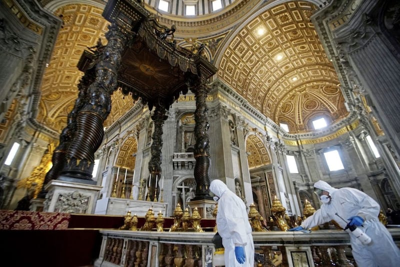 Workers in protective gear sanitise beneath the baroque sculpted bronze canopy of St Peter&#39;s Baldachin inside St Peter&#39;s Basilica at the Vatican. Picture by AP Photo/Andrew Medichini 