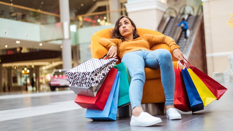 Woman relaxing in comfortable seat in busy shopping centre