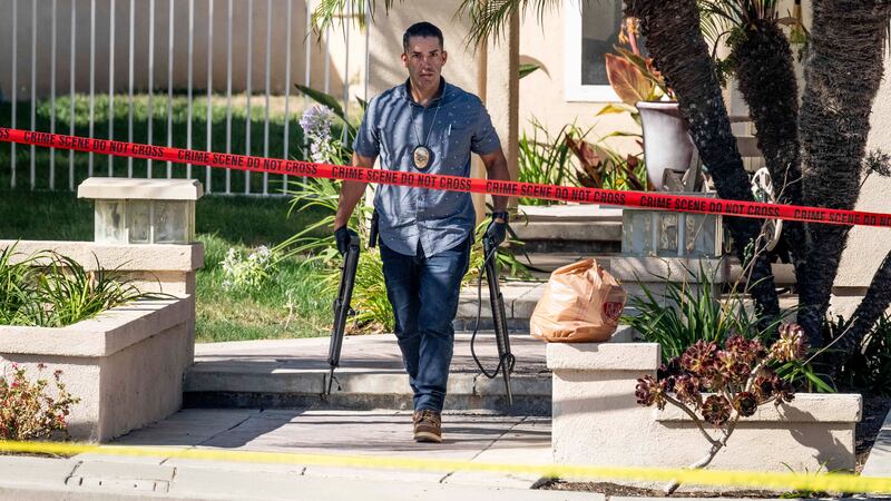 Investigators remove firearms from a house in Anaheim (Paul Bersebach/The Orange County Register via AP)